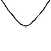Black beaded necklace with a silver clasp on a white background