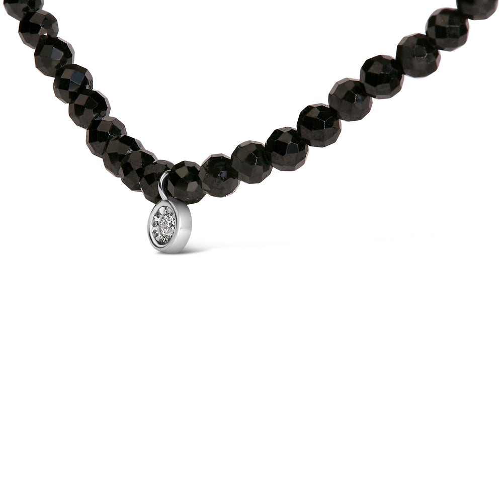 Black beaded necklace with a silver pendant on a white background