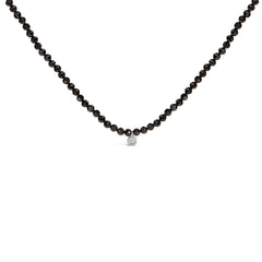 Black beaded necklace with a silver clasp on a white background