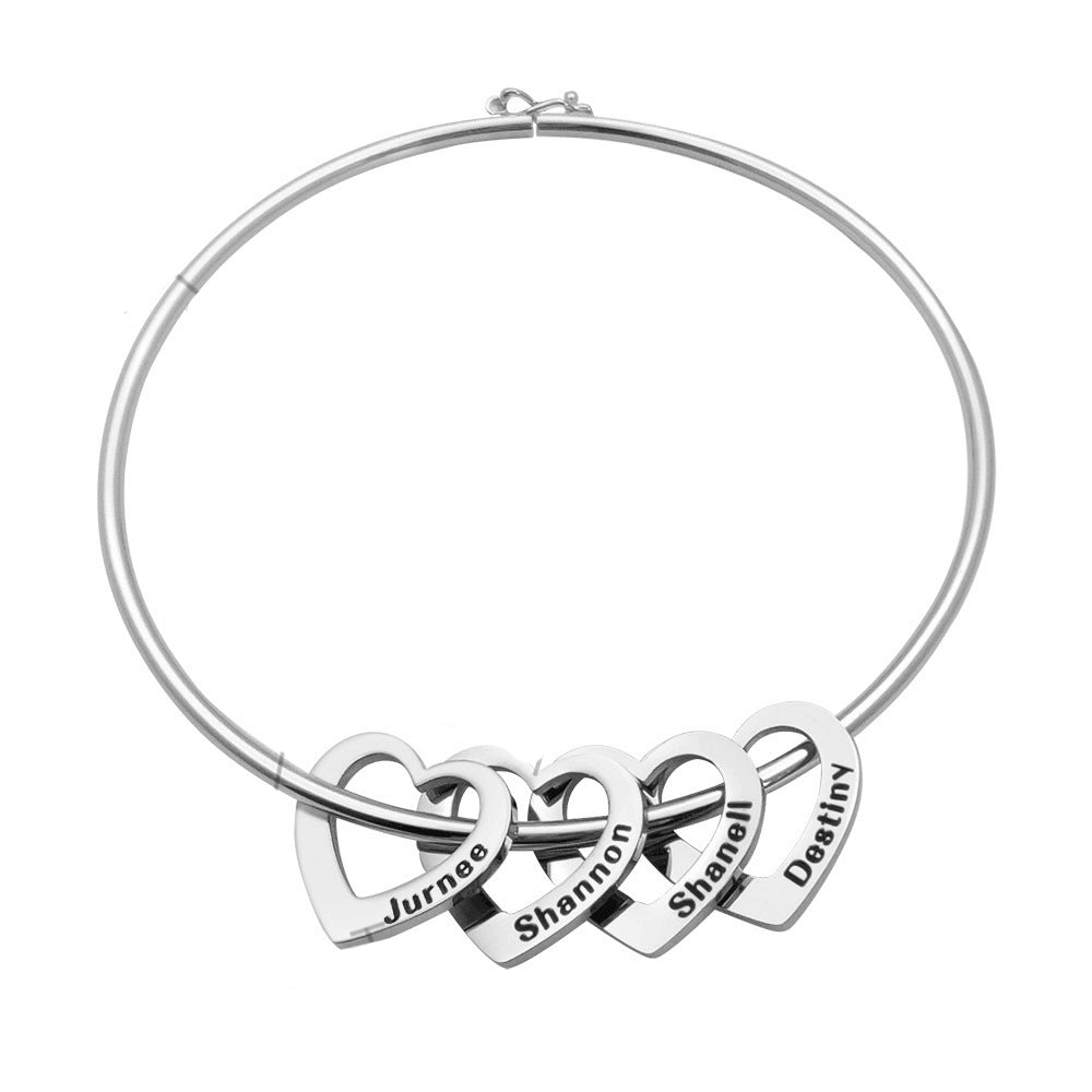 Silver necklace with interlocking heart pendants engraved with names on a white background