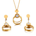 Gold jewelry set with circular designs and diamond-like stones on a white background