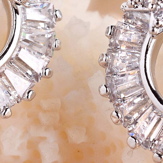 Close-up of diamond earrings on a beige background