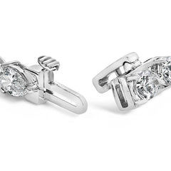 Close-up of two diamond earrings on a white background