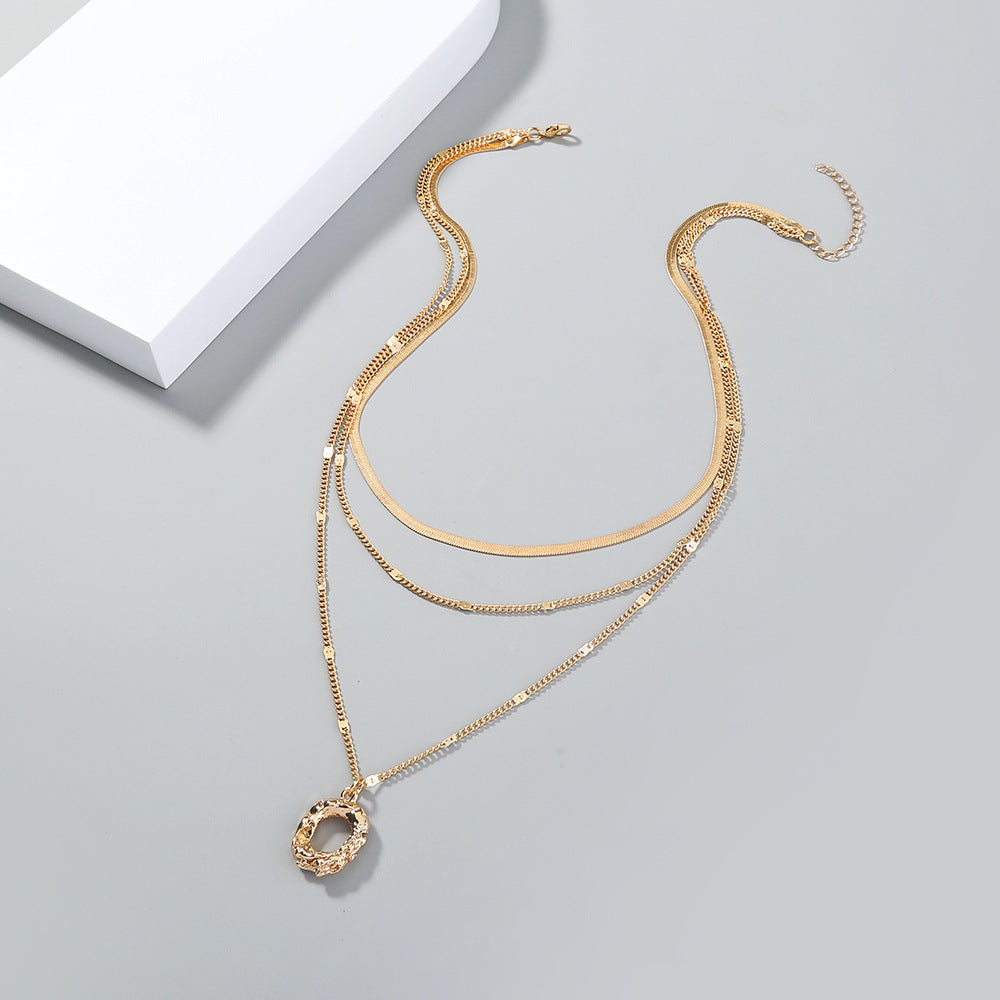 Gold necklace with a pendant on a light gray background