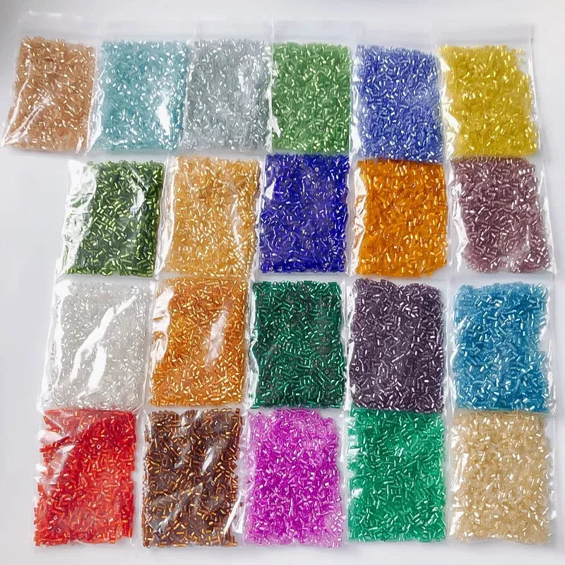 Assorted colored beads in clear plastic bags on a white background