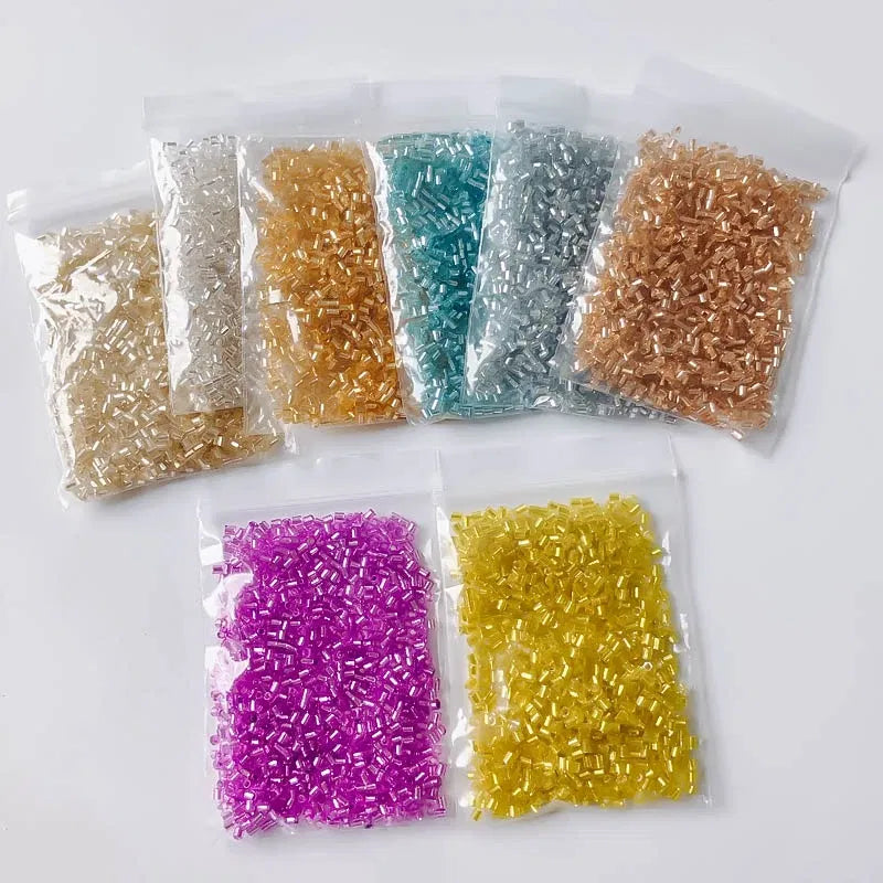 Assorted colored beads in clear plastic bags on a white background