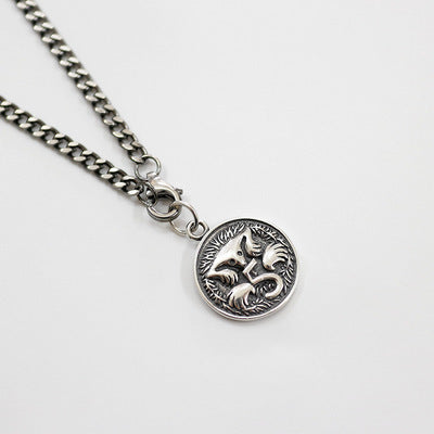 Silver chain necklace with a fox pendant on a light gray background