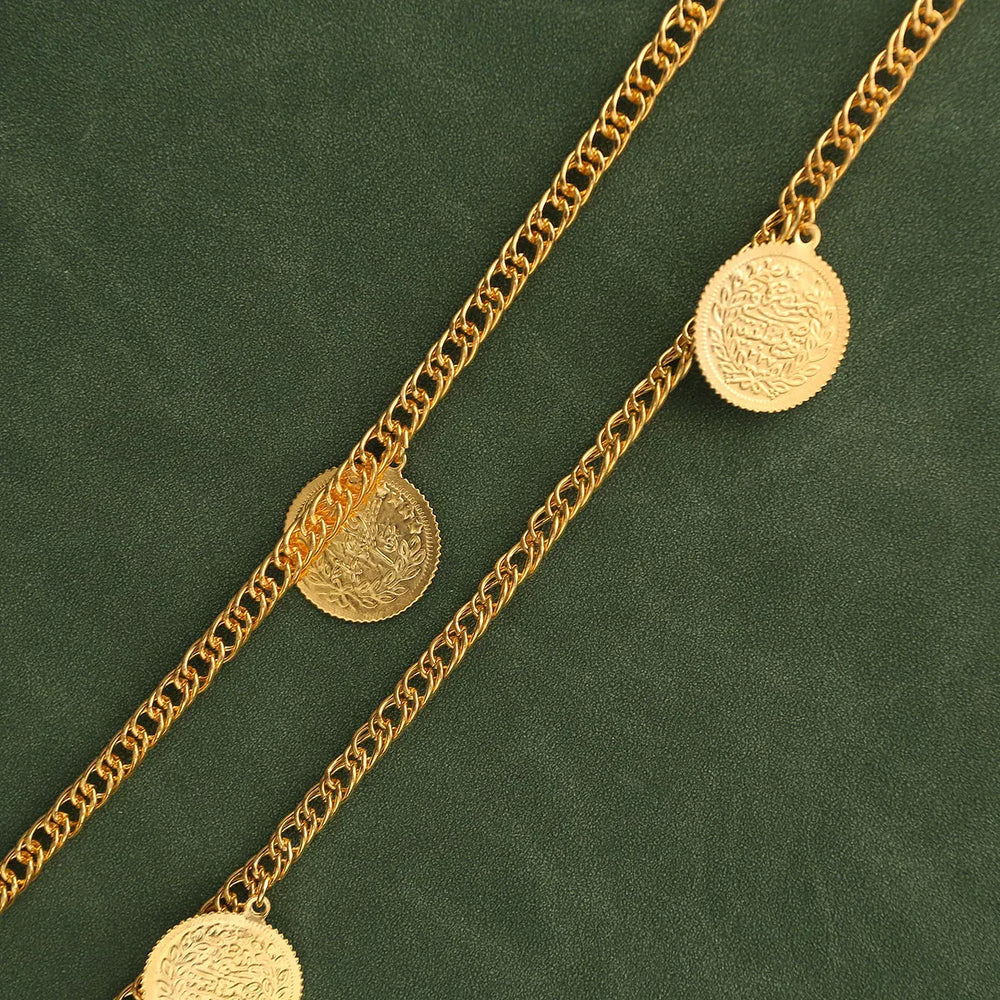 Gold chain necklace with coin pendants on a green background