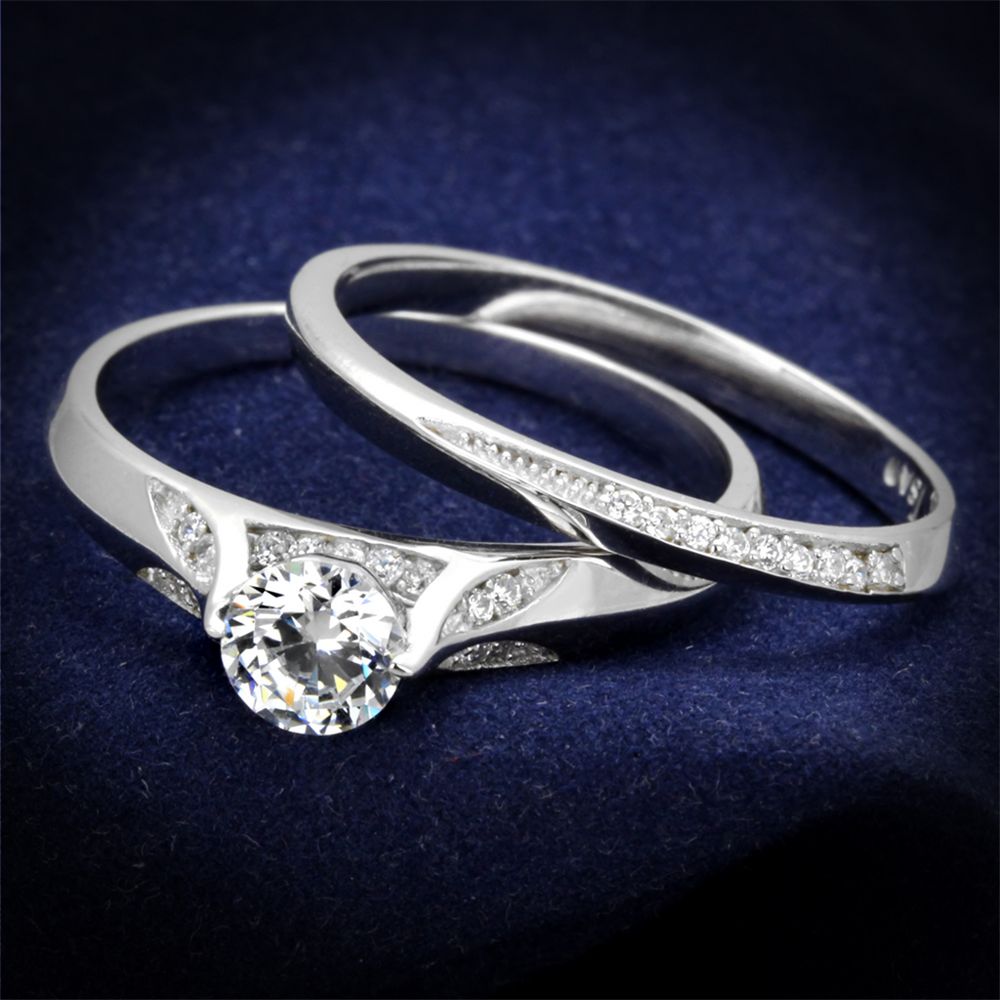 Two silver rings with diamond accents on a dark blue background