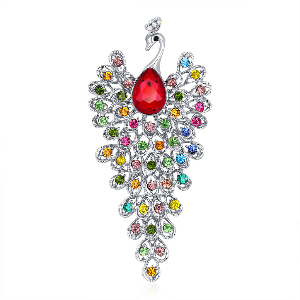 Jewelry pendant shaped like a peacock with multicolored gemstones on a white background