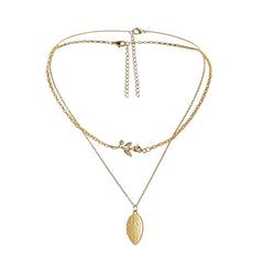 Gold necklace with leaf pendant on a white background